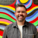Neil Griffiths standing in front of a colourful wall