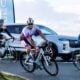 2025 IRONMAN competitors cycle alongside JAECOO vehicle