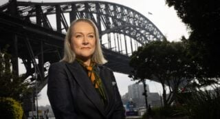 Moira Hogan stands in front of the Sydney Harbour Bridge