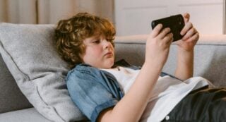 Kid watches YouTube on a phone