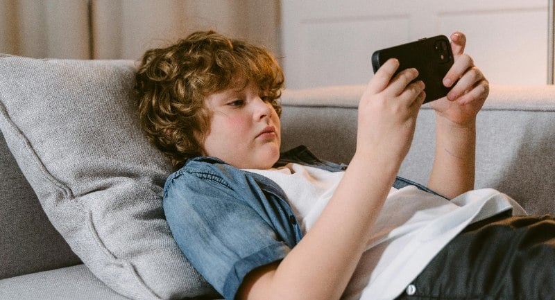 Kid watches YouTube on a phone