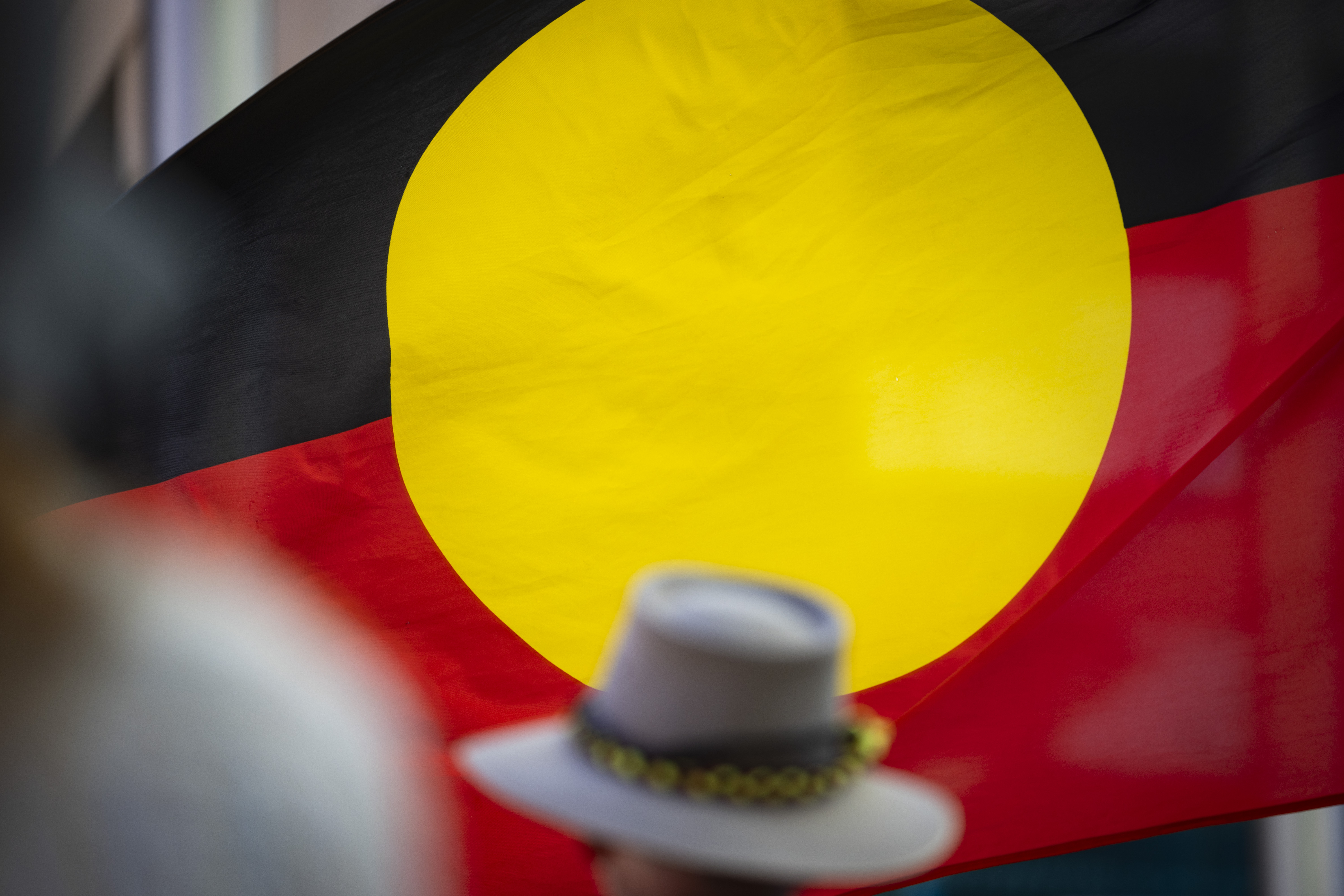An Aboriginal flag is seen through the crowd at the "Stop Black Deaths In Custody" march on October 7, 2023 in Boorloo.