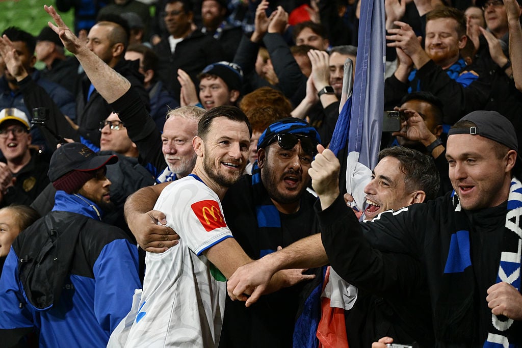 Auckland FC player Tommy Smith celebrates with fans