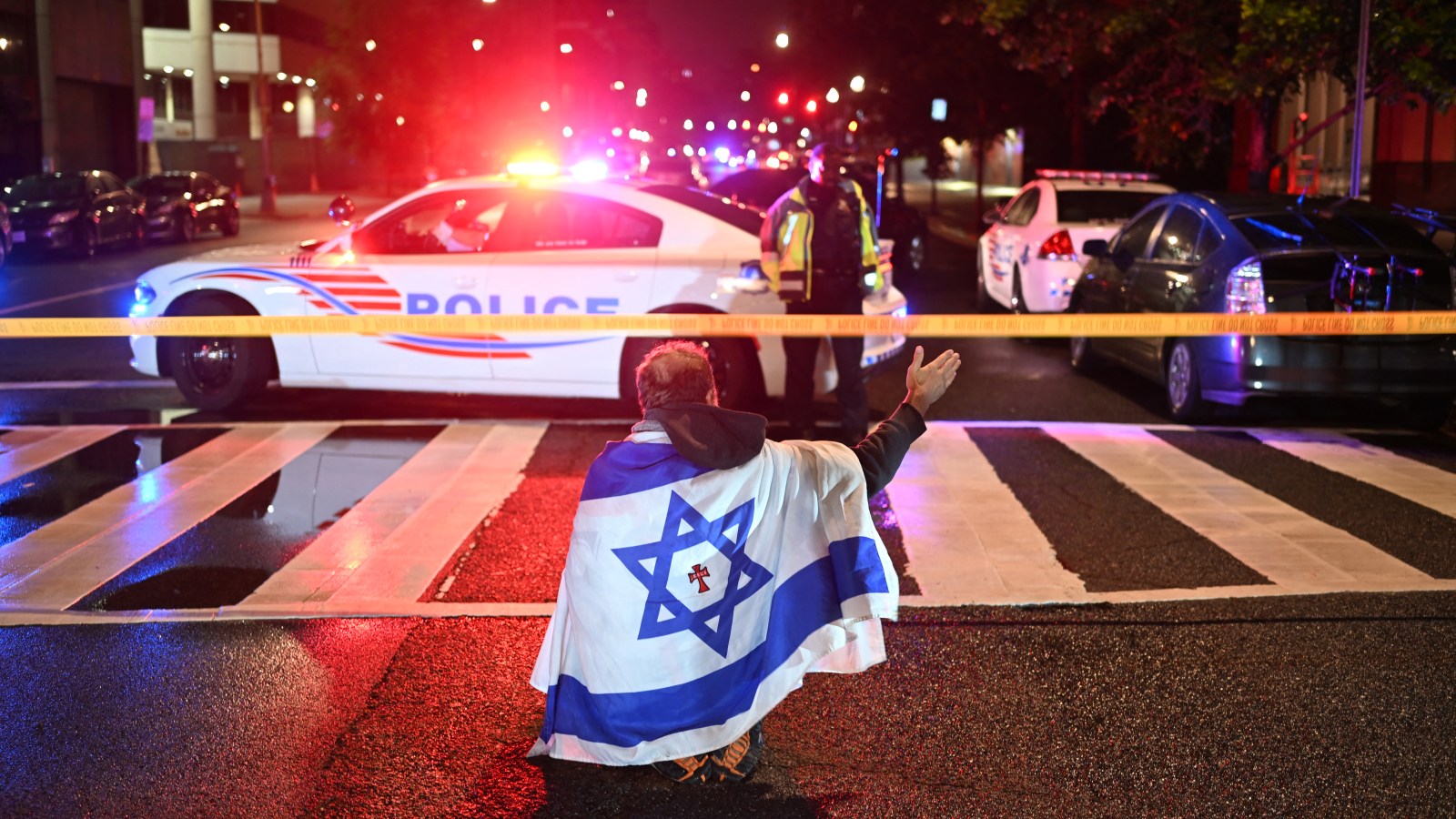 Metropolitan Police officers secure the area outside the Capital Jewish Museum following a shooting