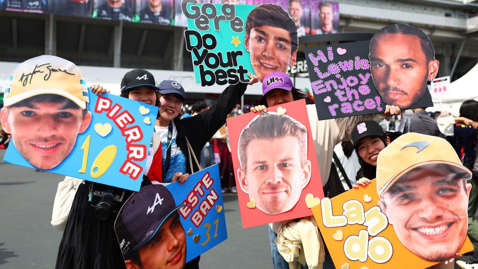 Fans hold posters supporting F1 drivers Pierre Gasly, Esteban Ocon, George Russell, Lewis Hamilton, Nico Hulkenberg, and Lando Norris at the F1 Grand Prix of Japan.