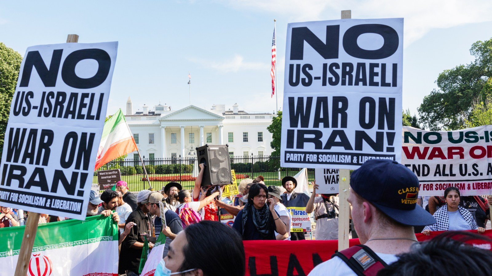 Demonstrators holding signs that read "No US-Israel War on Iran" join a protest in front of the White House