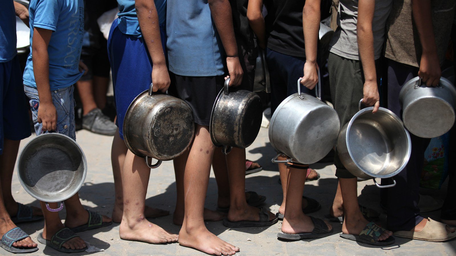 A large number of Palestinians, including children, gather in order to obtain food Gaza