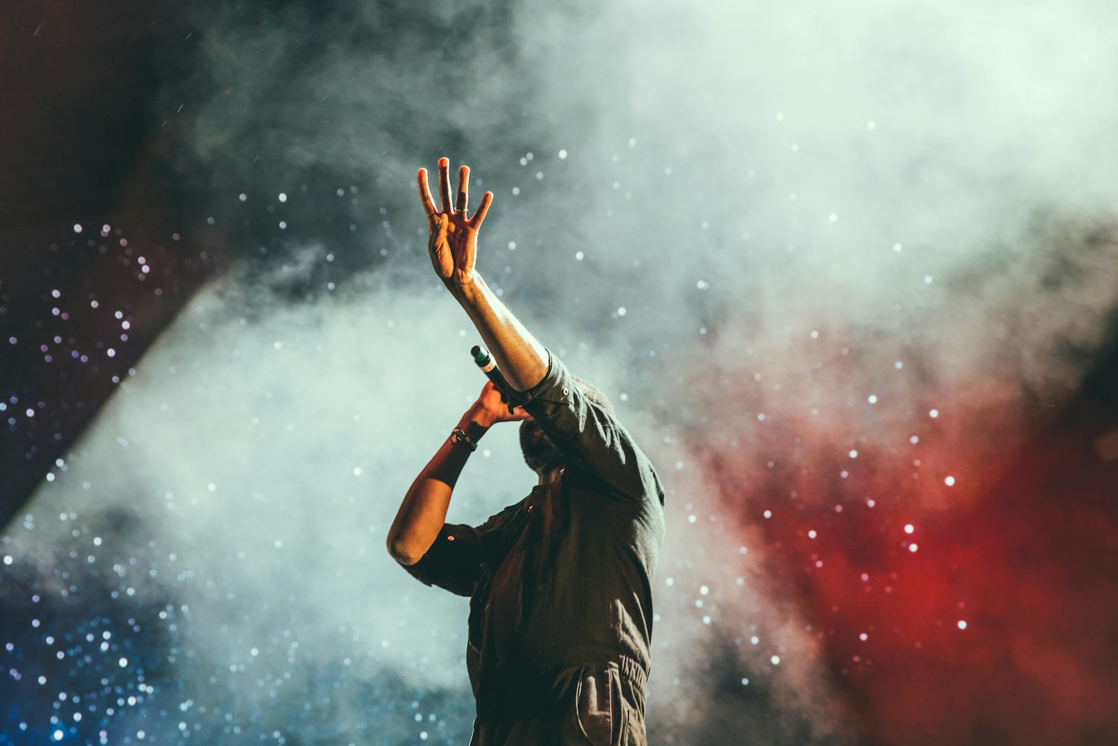 Pop artist performing on stage under neon lights