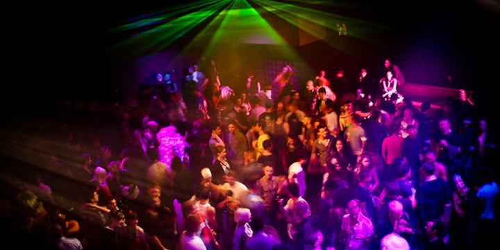 A crowd enjoying electronic music beneath laser light