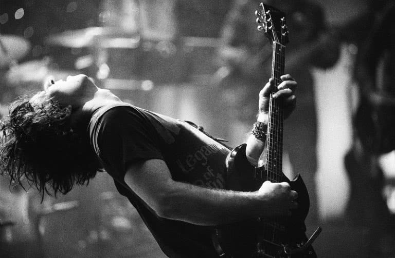 black and white live shot of Ryan Adams with his head thrown back, playing guitar