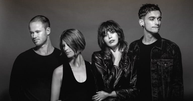 Four band members of The Jezabels, all wearing black , shot in a studio in black and white