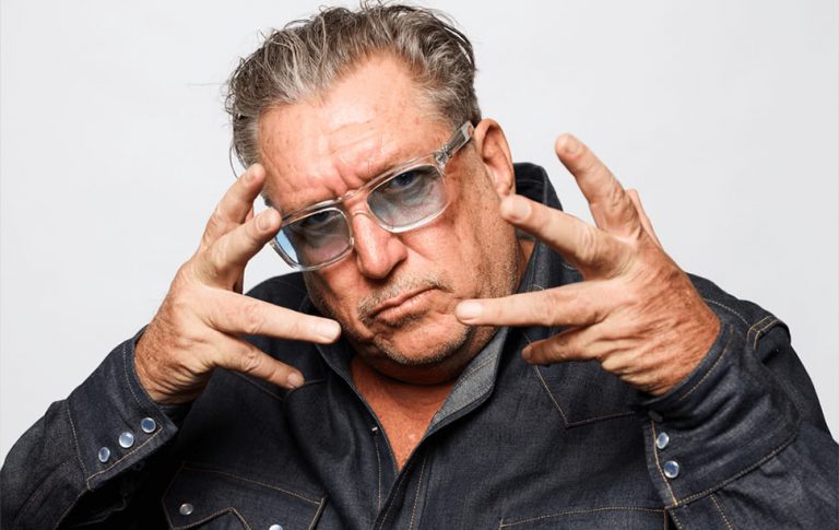 The Sex Pistols' Steve Jones looking at the camera with his hands by his face