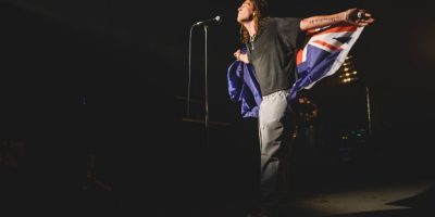 Lany's Paul Klein performs wrapped in an Australian flag on the stage of Sydney's Metro Theatre