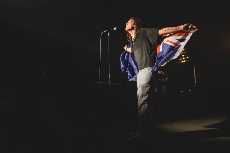 Lany's Paul Klein performs wrapped in an Australian flag on the stage of Sydney's Metro Theatre