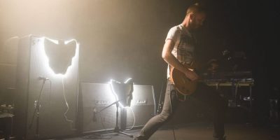 Luca Brasi guitarist Patrick Marshall playing the Metro Theatre, with fluorescent maps of Tasmania lighting the band's amps.