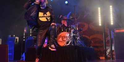 Corey Taylor of Stone Sour leaps about in front of the drum kit, Wu Tang shirt prominent