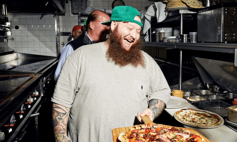 Action Bronson laughs as he cooks a pizza
