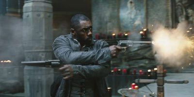Idris Elba as The Gunslinger, firing two crossed pistols in The Dark Tower