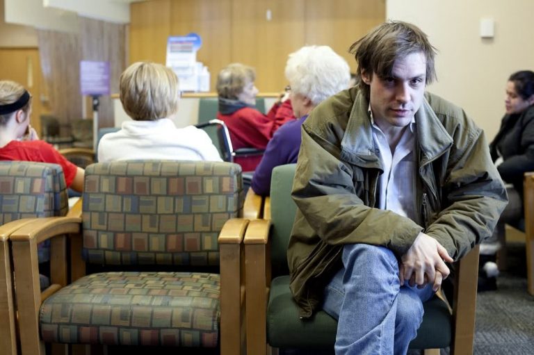 John Maus sitting in a waiting room