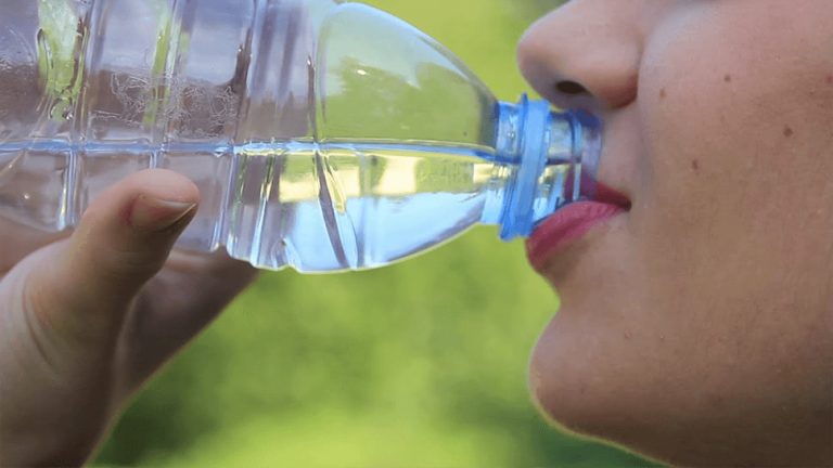 Image of a female drinking a bottle of water