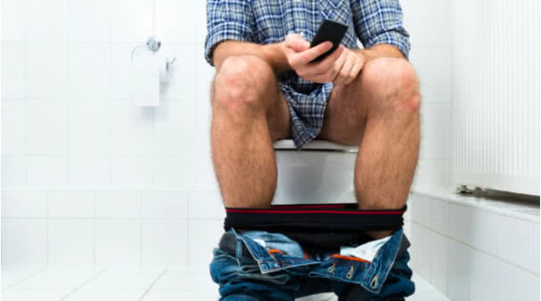 Image-man-using-phone-on-toilet