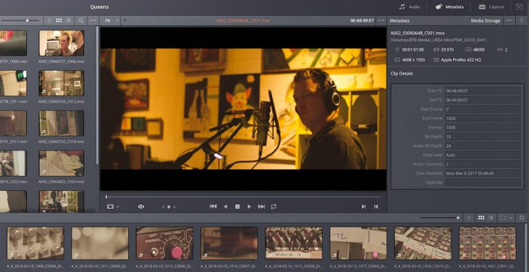 Screenshot of video editing man with headphones on in from of microphone