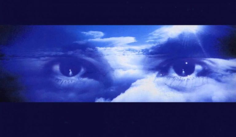 Robert Miles' eyes floating through blue and white clouds.