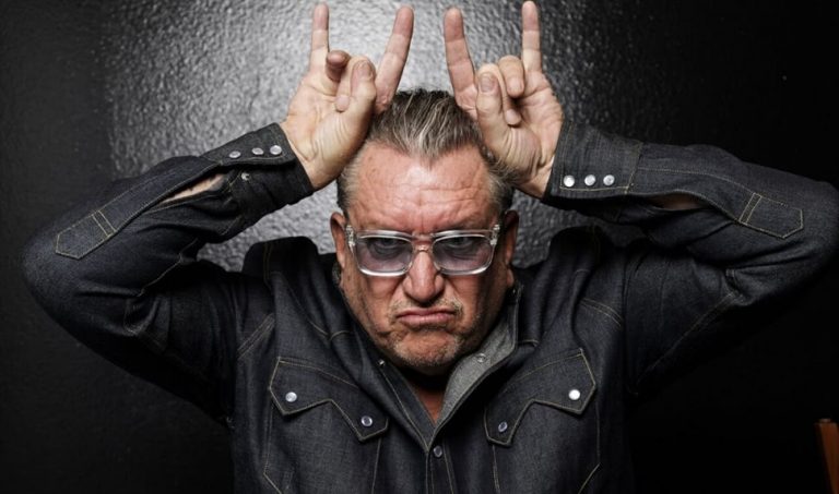 Sex Pistols' Steve Jones giving a double-handed 'devil horns' salute