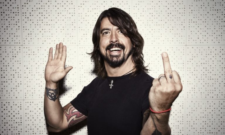 Dave Grohl smiling and giving the finger