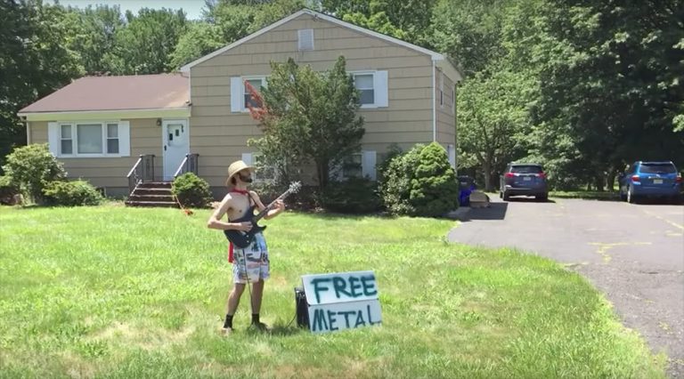 Screenshot of a YouTube video showing a caped musician playing guitar