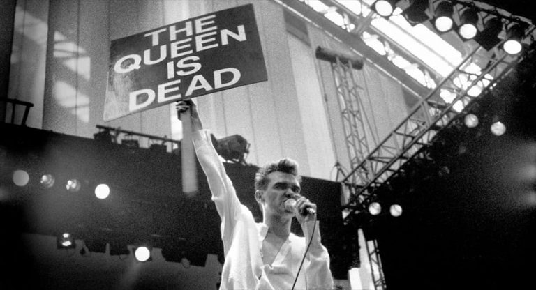 The Smiths' Morrissey holding a sign while performing live
