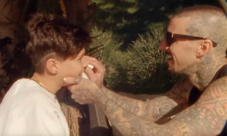Travis Barker places a temporary tattoo on his son's face