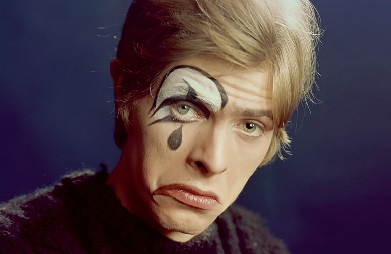 A young David Bowie wearing sad clown makeup