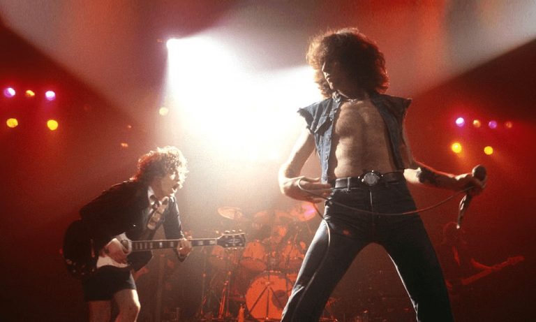 Bon Scott plays with Angus Young