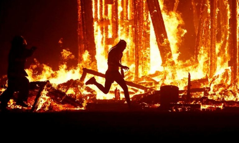 A man runs into the flames at Burning Man festival