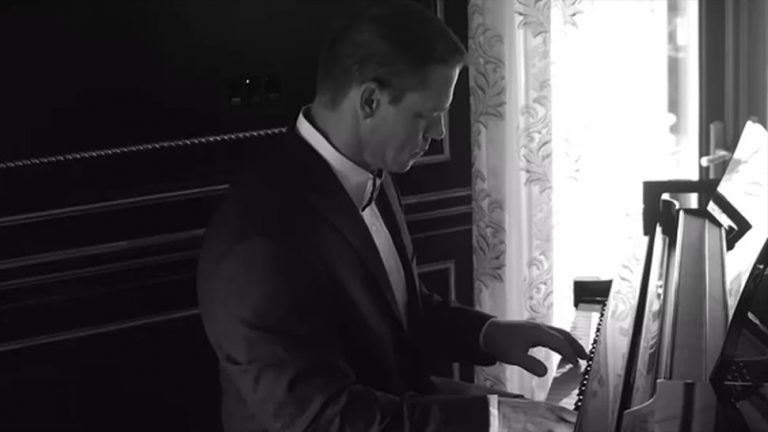 Wrestling legend John Cena playing the piano in a tuxedo