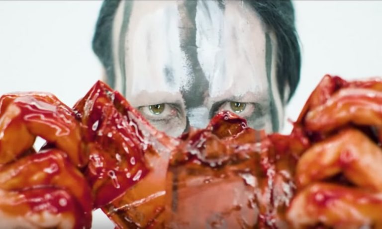 Marilyn Manson tears a bloody dollar bill