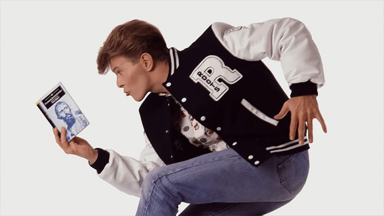 David Bowie, reading a book in a rather cheesy promotional photo