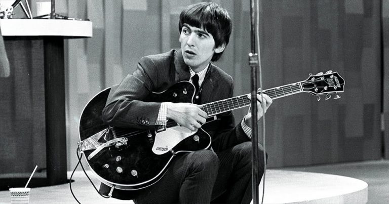 Late member of The Beatles, George Harrison, sitting with his guitar