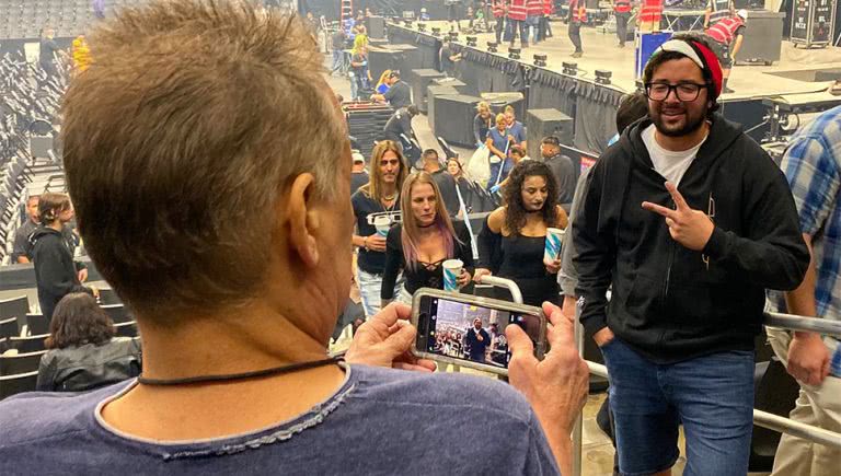 Image of Eddie Van Halen taking a photo of a fan at a Tool concert