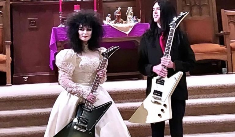 The couple with their Gibson guitars at their wedding