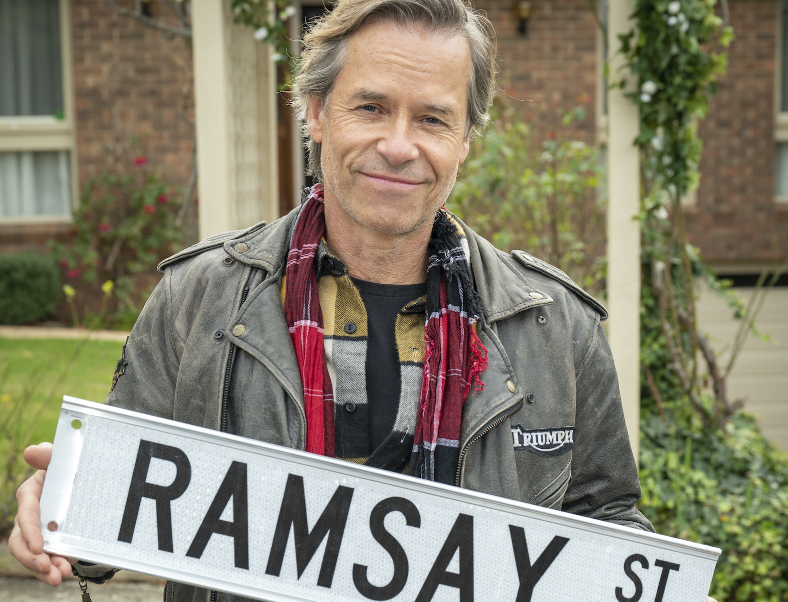 Guy Pearce holding Ramsay Street sign